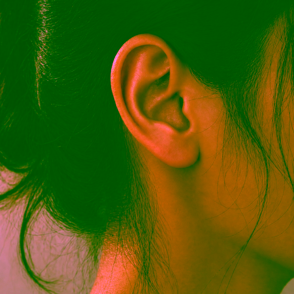 Oreille vue de profil portant une puce d'oreille en diamant à sa taille réelle
